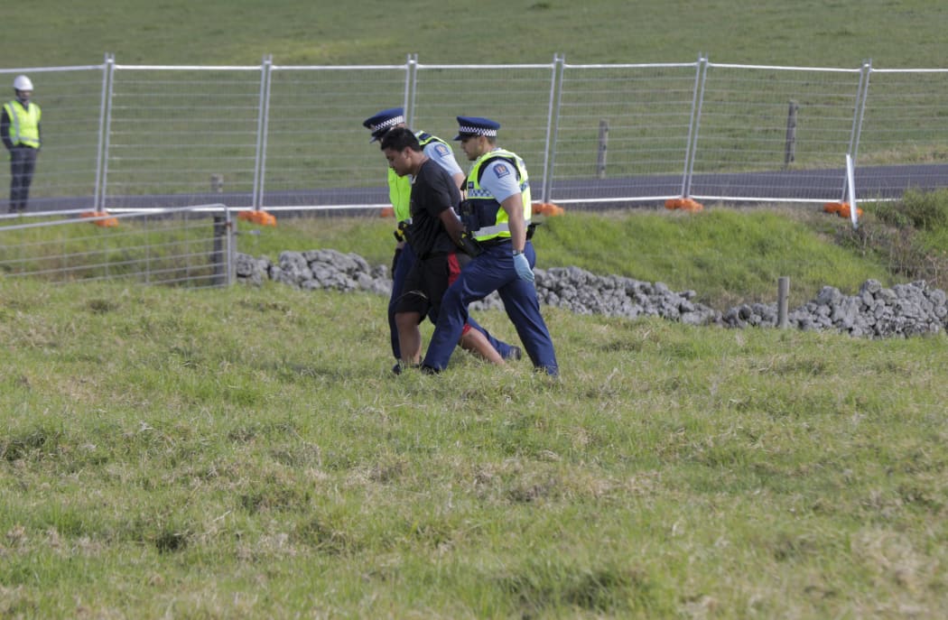 A man is taken into custody at Ihumatao.