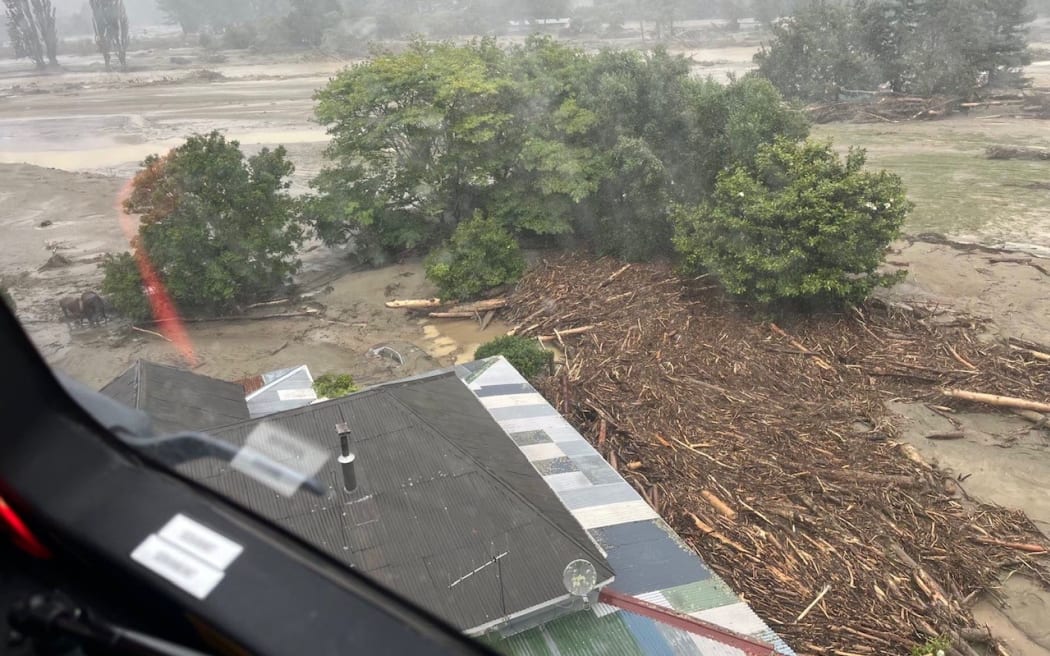 An NH90 helicopter and crew recover people from the rooftops of their homes in Esk Valley, Napier.