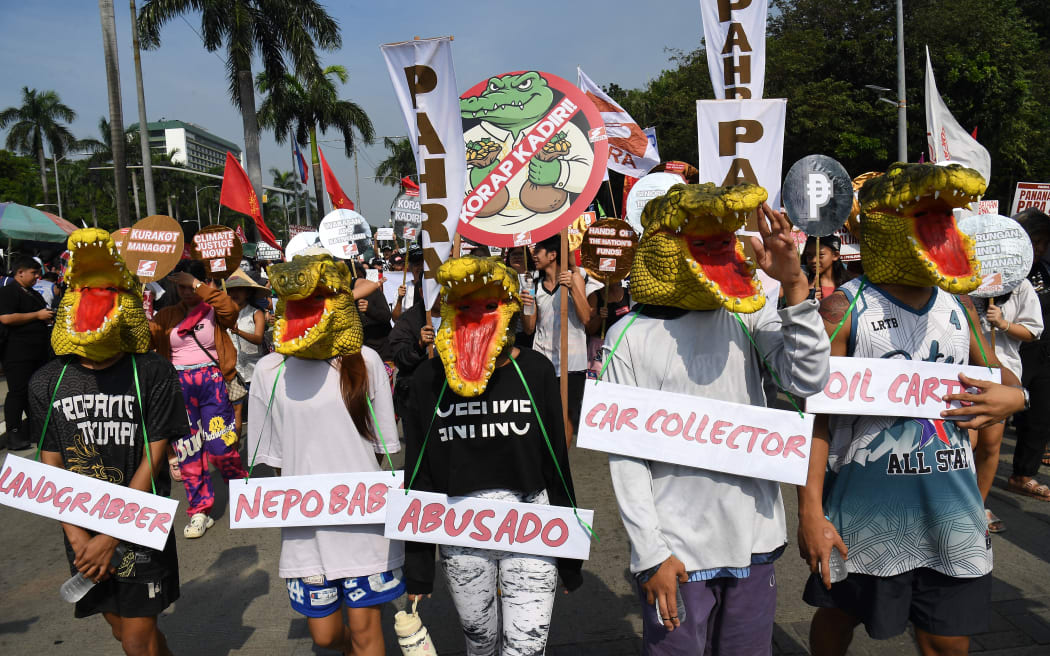 Protesters wearing crocodile masks march during an anti-corruption rally near a park on Manila on November 30, 2025.