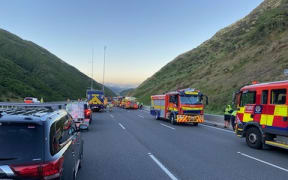 Fire trucks, a tanker and a specialist hazardous materials unit at the scene of a fuel spill that closed Transmission Gully, 4 April 2023.