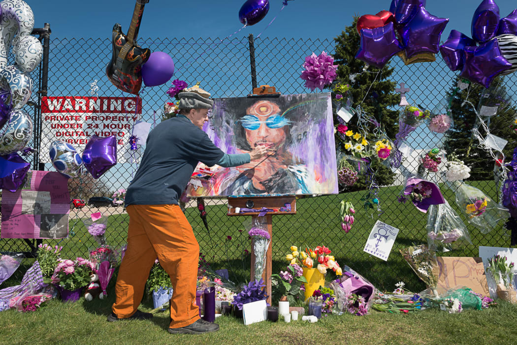 Prince fan Dan Carey contributes to a memorial outside of Paisley Park, Prince's home and studio, in Chanhassen, Minnesota.