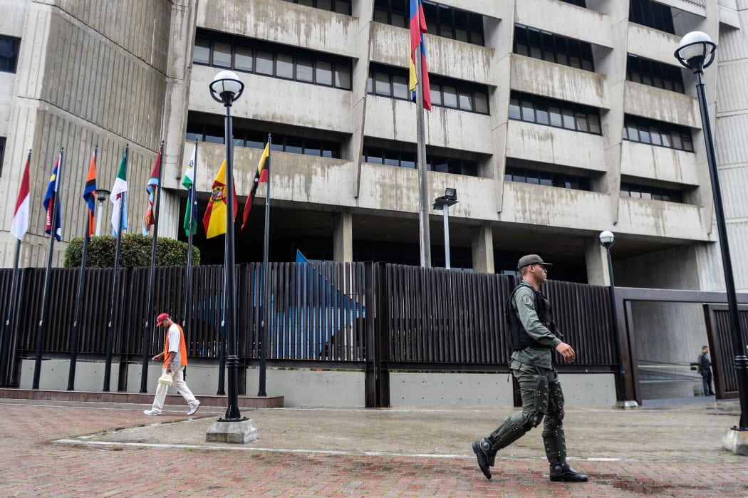 A member of the National Guard walks past the Supreme Court building in Caracas.
