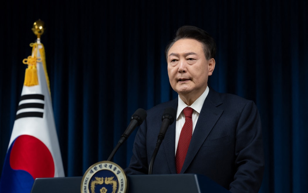 This handout photo taken and released on December 7, 2024 by the South Korean Presidential Office shows South Korea's President Yoon Suk Yeol delivering an address at the Presidential Office in Seoul. - South Korea's embattled President Yoon Suk Yeol stopped short of resigning on December 7 over his declaration of martial law, with a vote to impeach him hours away and mass street protests planned in Seoul. (Photo by Handout / South Korean Presidential Office / AFP) / RESTRICTED TO EDITORIAL USE - MANDATORY CREDIT "AFP PHOTO / SOUTH KOREAN PRESIDENTIAL OFFICE" - NO MARKETING NO ADVERTISING CAMPAIGNS - DISTRIBUTED AS A SERVICE TO CLIENTS / “The erroneous mention[s] appearing in the metadata of this photo by Handout has been modified in AFP systems in the following manner: [2024] instead of [2023]. Please immediately remove the erroneous mention[s] from all your online services and delete it (them) from your servers. If you have been authorized by AFP to distribute it (them) to third parties, please ensure...