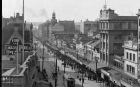 George Edward Thompson published his thesis on the New Zealand English accent in 1921. Pictured is an image of Queen Street, Auckland Central, taken that same year