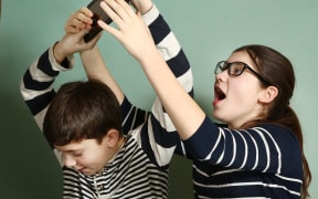 65478991 - teen siblings couple brother and sister in glasses fighting because of tablet try to take it for gaming