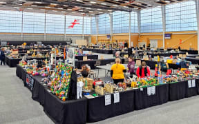A large hall filled with tables holding LEGO displays.