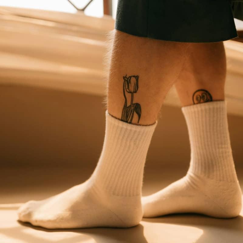 A pair of masculine calves in white socks.