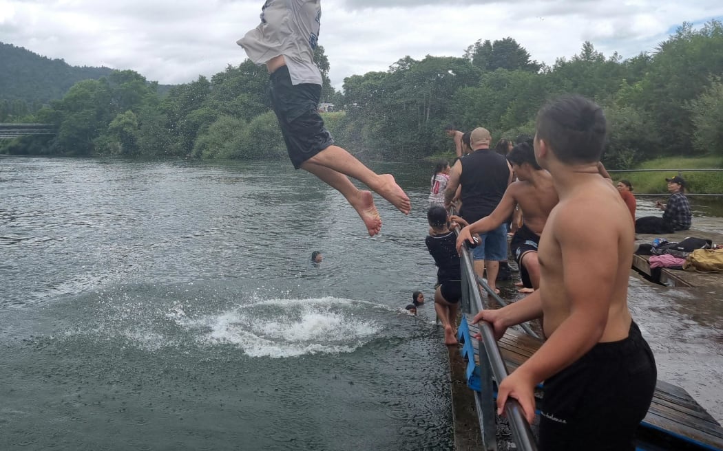 Rangatahi cooling off in the Waikato River next to Tūrangawaewae Marae during the hui-ā-motu called by the Māori King.
