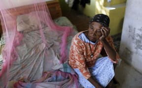 Aurea Cruz, 66 sits on her bed inside her house damaged by Hurricane Maria in Viegues, Puerto Rico.