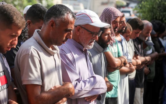 Mourners pray by the bodies of victims who were killed the previous day by Israeli bombardment as they lie outside during the funeral at Nasser Medical Complex in Khan Yunis in the southern Gaza Strip on July 20, 2025. (Photo by AFP)