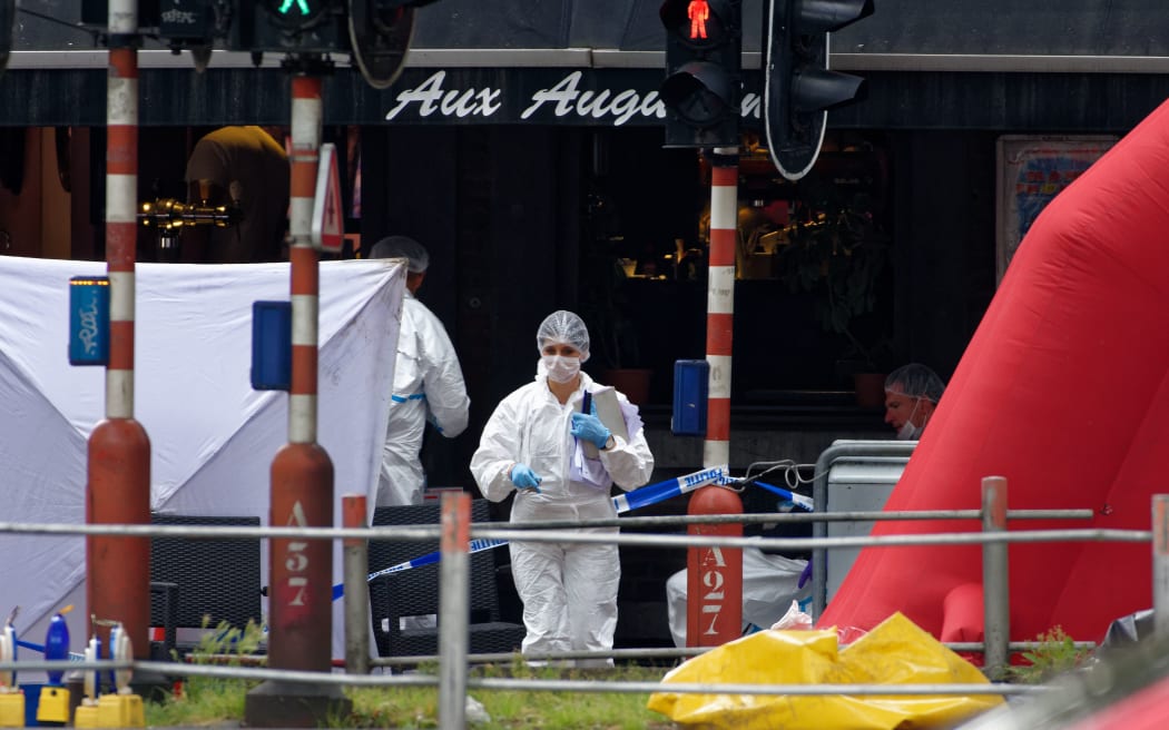 Forensic investigators work at the scene where a gunman shot dead two police officers and a bystander in the eastern Belgian city of Liege.