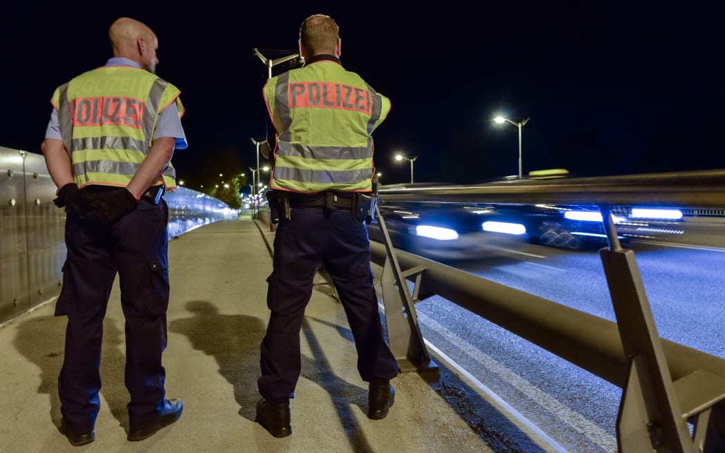 Two police officers observe the traffic at the border between Germany and Austria.