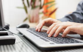 Man typing on a computer.