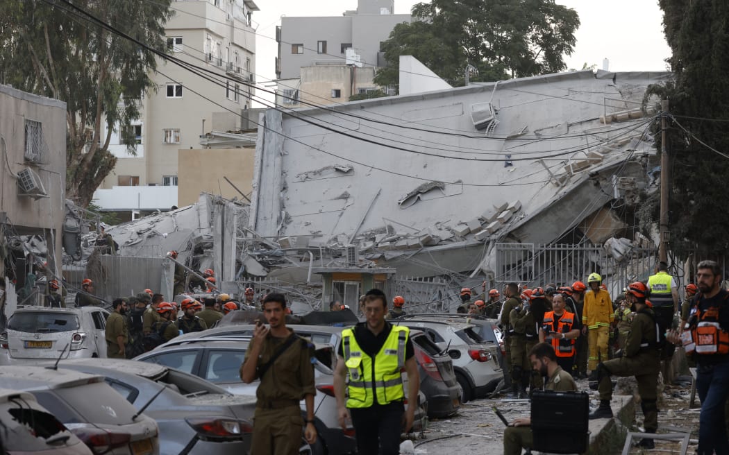 Rescuers work near a damaged building following a strike by an Iranian missile in the Israeli city of Bnei Brak, east of Tel Aviv.