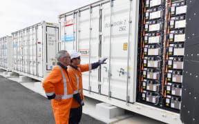From left, project manager Mike Wilson and field service engineer Minh Nguyen check out the battery modules inside one of the 80 containers that make up Meridian's new Battery Energy Storage System, on 23 May 2025.