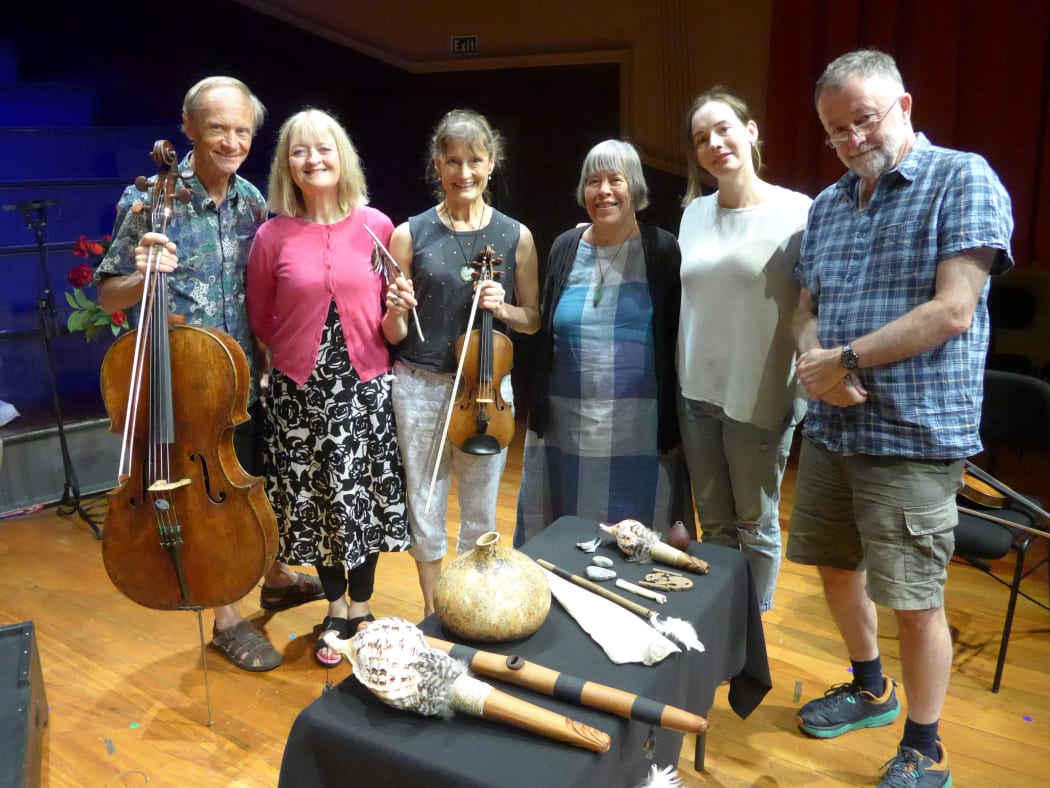 Dame Gillian Whitehead with Bob Bickerton and the New Zealand String Quartet pose on stage with taonga puoro