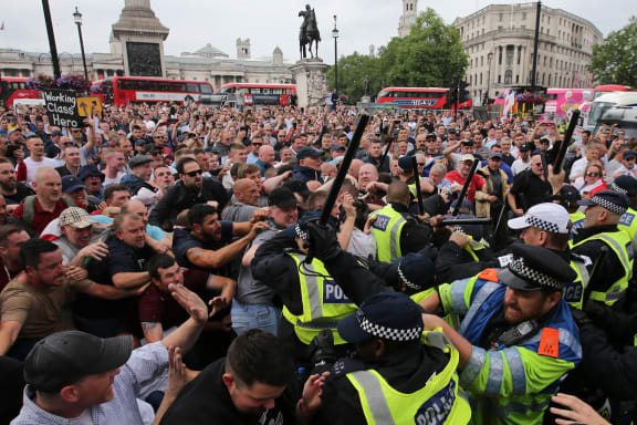 Protesters scuffle with police at the junction of Whitehall and The Mall during a gathering by supporters of far-right spokesman Tommy Robinson in central London on June 9, 2018, following the jailing of Tommy Robinson for contempt of court. (Photo by Daniel LEAL-OLIVAS / AFP)