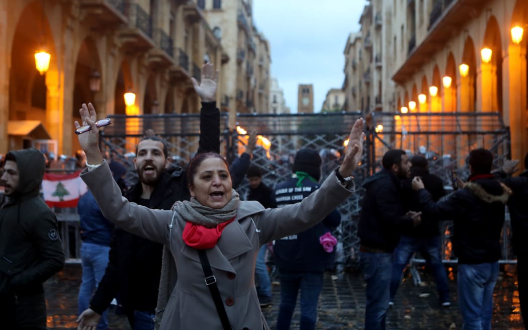Lebanese anti-government protesters gather by the barricaded road leading to parliament in central Beirut on January 19, 2020.