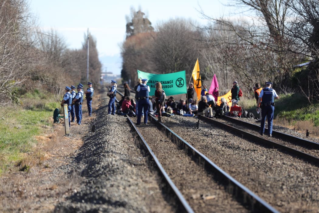 30 Extinction Rebellion members sat on the train tracks in Woolston near Christchurch on Friday, 9 August.