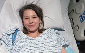 Bindi Irwin lying in hospital bed.