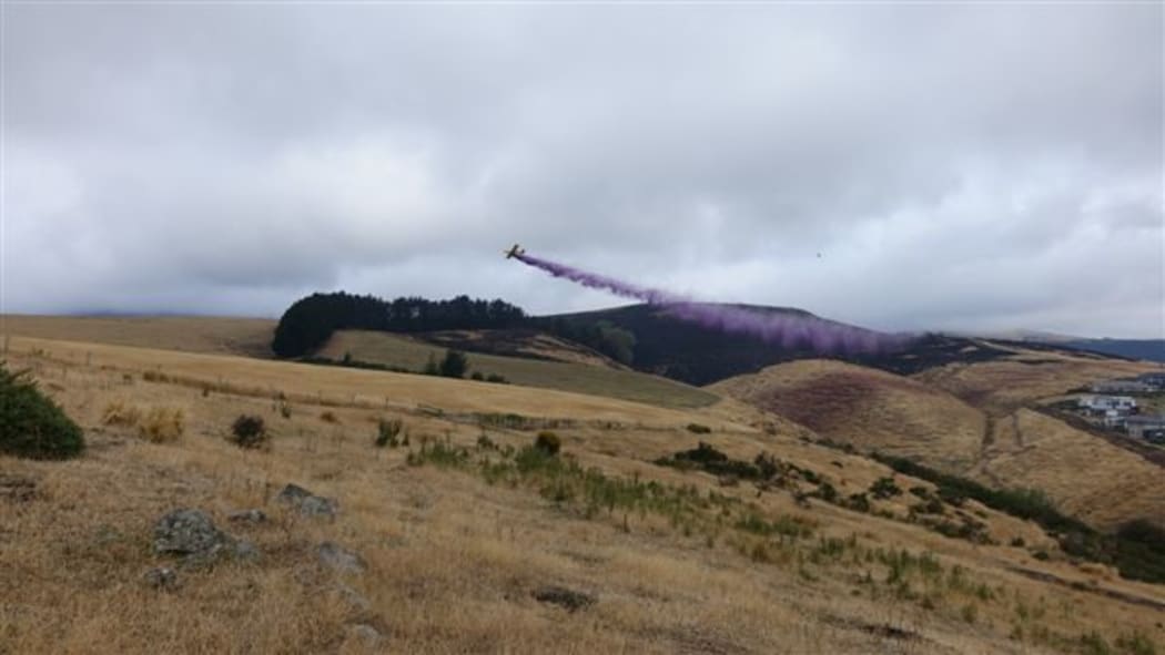 A plane dropping fire retardant over the Port Hills.