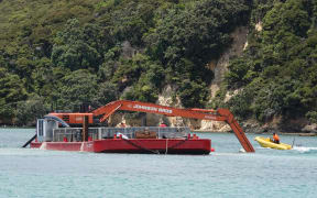 The Johnson Brothers suction dredge in action at Omākiwi Cove, near Rāwhiti in the Bay of Islands.