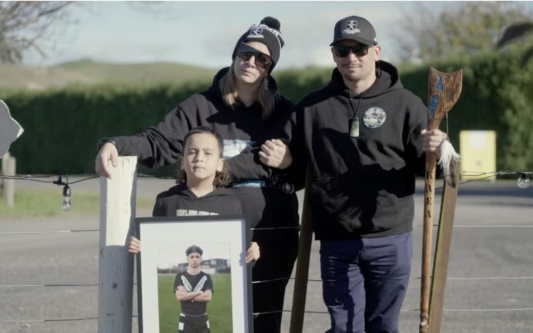 Kaea Karauria’s whānau holding a photo of him.