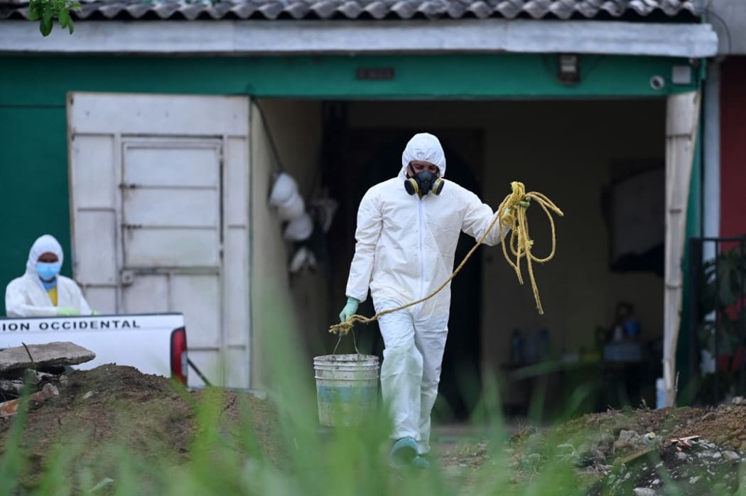Forensic scientists work at the home of former in El Salvador police officer Hugo Ernesto Osorio.