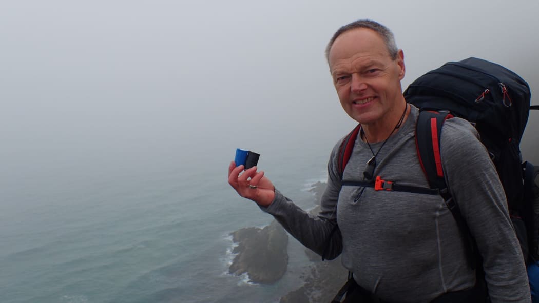 Bruce Hopkins with the urns of ashes at Cape Reinga, at the start of his journey