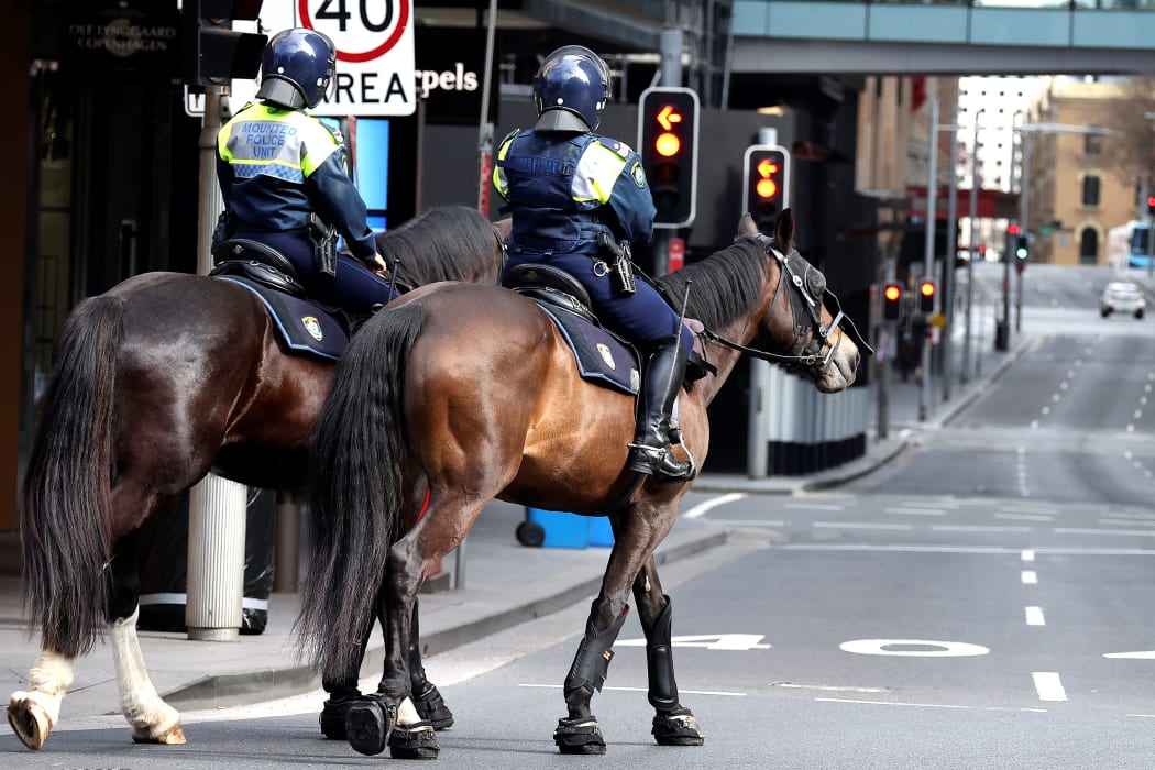 Police on horses patrol the central business district of Sydney on Saturday, as authorities warned against the anti-lockdown protest.