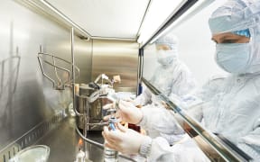 female science researchers in protective uniform and equipment works with dangerous hazard virus material at microbilogy laboratory- vaccine generic