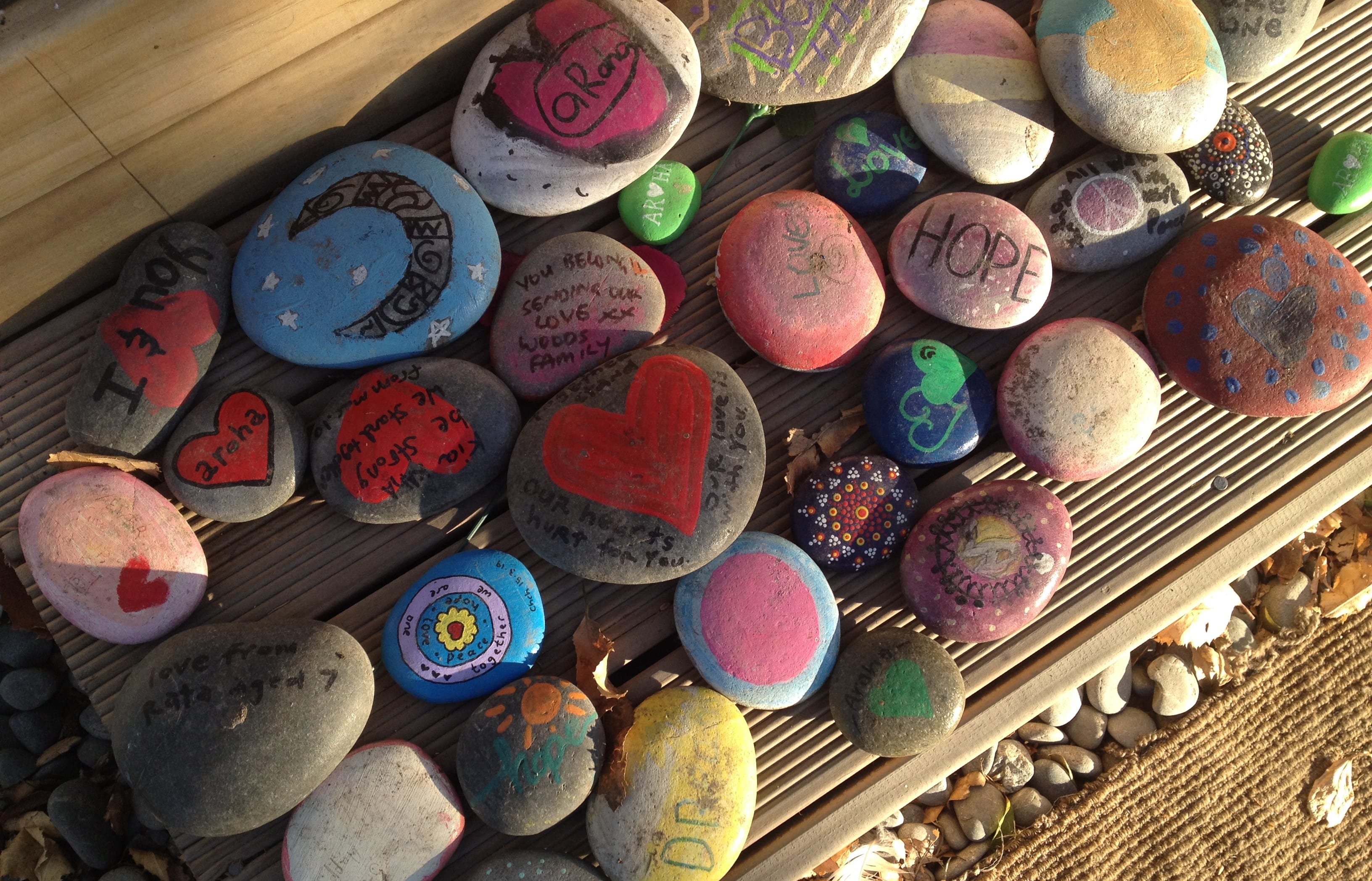 Rocks left outside the footsteps of Linwood Mosque with messages of strength and solidarity.