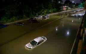 Floodwater surrounds vehicles following heavy rain on an expressway in Brooklyn, New York