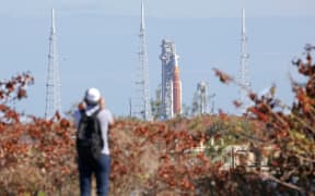 NASA's Artemis II Space Launch System (SLS) rocket and Orion spacecraft are seen in the distance at Launch Pad 39B at Kennedy Space Center in Cape Canaveral, Florida, on February 20, 2026. NASA performed their second wet dress rehearsal prior to sending four astronauts to the moon for the first time in more than 50 years. NASA officials said they are targeting March 6 for the crewed flight to the moon. (Photo by Gregg Newton / AFP)