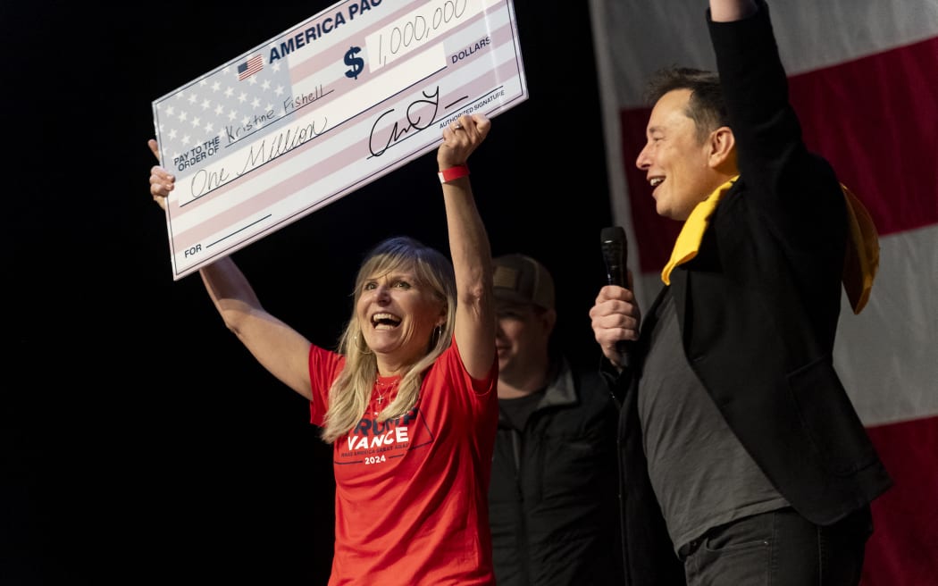 PITTSBURGH, PENNSYLVANIA - OCTOBER 20: SpaceX and Tesla founder Elon Musk awarded Kristine Fishell with a $1 million check during the town hall at the Roxain Theater on October 20, 2024 in Pittsburgh, Pennsylvania. Musk has donated more than $75 million to America PAC, which he co-founded with fellow Silicon Valley venture capitalists and tech businessmen to support Republican presidential nominee, former U.S. President Donald Trump.   Michael Swensen/Getty Images/AFP (Photo by Michael Swensen / GETTY IMAGES NORTH AMERICA / Getty Images via AFP)