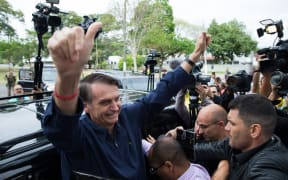Brazil's right-wing presidential candidate for the Social Liberal Party (PSL) Jair Bolsonaro gives his thumbs up after casting his vote at Villa Militar, during general elections.
