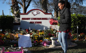 PARKLAND, FLORIDA - FEBRUARY 14: Sheena Billups prepares to lay flowers in a memorial setup at Marjory Stoneman Douglas High School for those killed during a mass shooting on February 14, 2019 in Parkland, Florida.