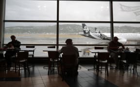 People wait at Wellington airport after foul weather forced the cancellation and delay of dozens of flights.