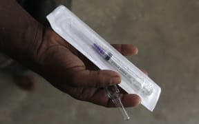 A HIV patient displays a new syringe and distilled water in Pakistan.