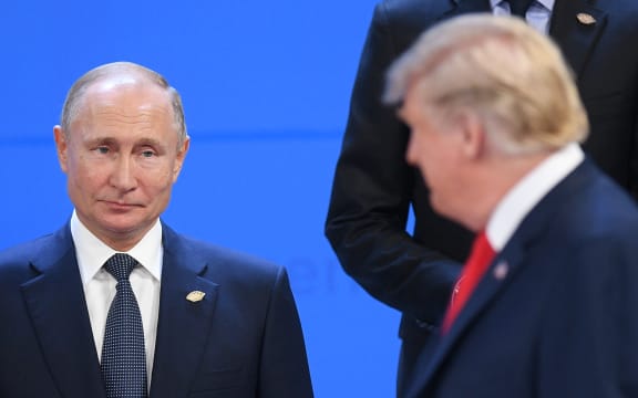 Russian President Vladimir Putin, left, looks at US President Donald Trump before posing for a family photo before the G20 summit in Argentina, 30 November, 2018.