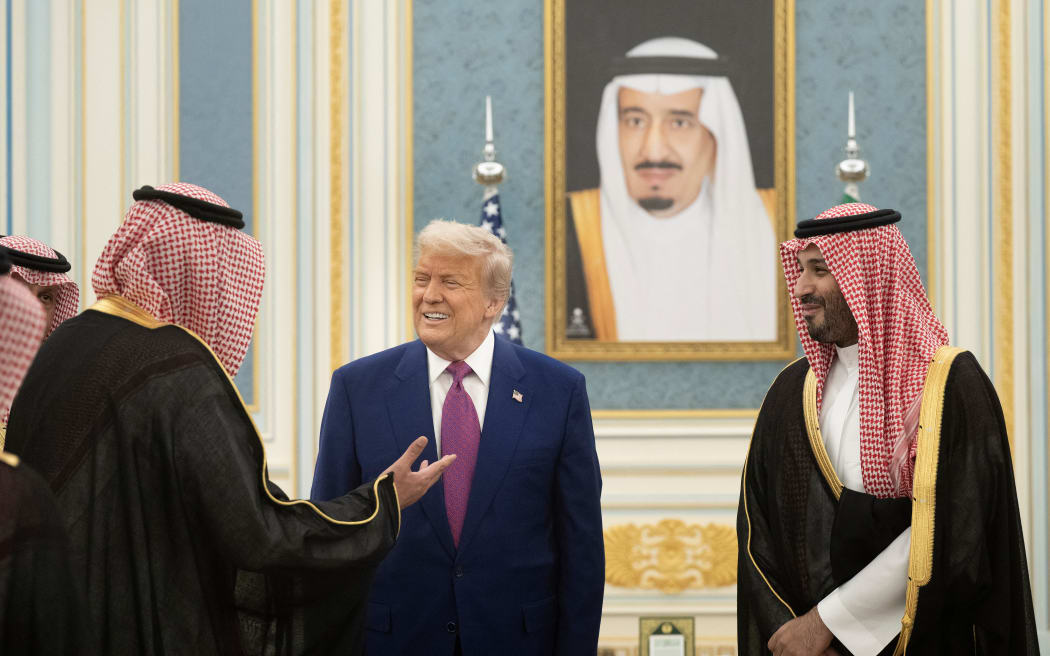 Saudi Crown Prince Mohammed Bin Salman (R) and US President Donald Trump greet delegation members at the Royal Court in Riyadh on May 13, 2025. (Photo by Brendan Smialowski / AFP)