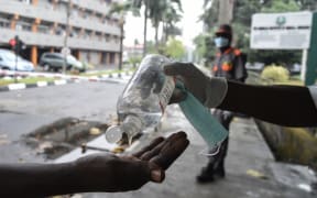 A visitor tries to sanitise hands before being allowed into a state hospital at Yaba in Lagos.