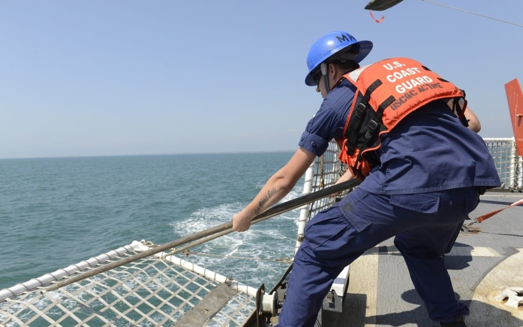 Seaman Justin Marohl lowers flight nets aboard the Coast Guard Cutter Active.