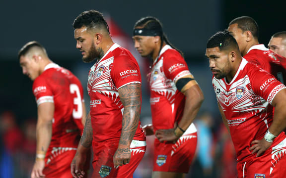 Tongan players stand dejected during Saturday's heavy defeat by the Kiwis.