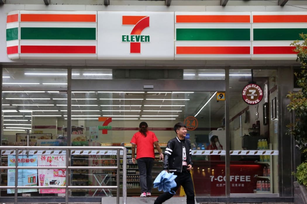 --FILE--A customer exits from a convenience store of 7-Eleven in Shanghai, China, 30 March 2015.