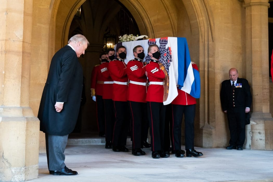 Pallbearers carry the coffin of Britain's Prince Philip, Duke of Edinburgh draped with his Personal Standard to the purpose built Land Rover Defender for the ceremonial funeral procession to St George's Chapel in Windsor Castle in Windsor, west of London, on April 17, 2021.