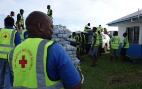 Vanuatu Red Cross workers load relief supplies brought in on a NZAF Hercules. Much needed tarpaulins, water containers and health and sanitation kits were being stored until further notice was given from the NDMO