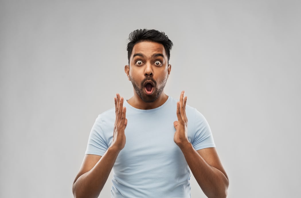 emotion, expression and people concept - scared man in t-shirt over grey background