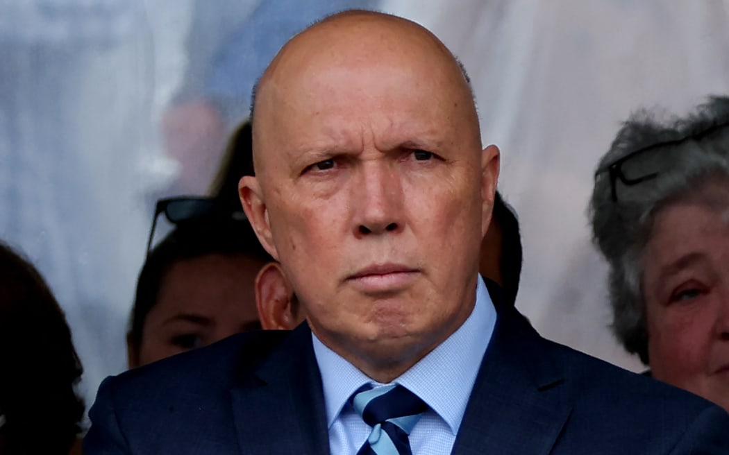 Australia's opposition leader Peter Dutton holds a flower as he attends a commemoration ceremony to mark the 20th anniversary of the Bali bombings, at Coogee Beach in Sydney on October 12, 2022. (Photo by DAVID GRAY / AFP)