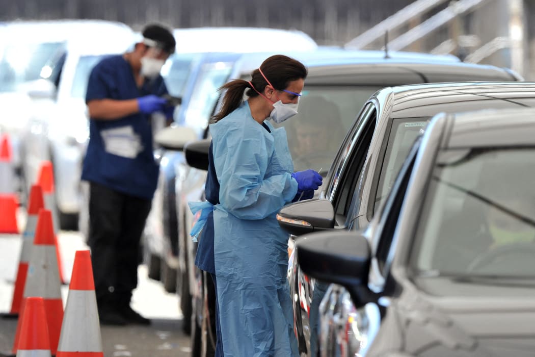 Health officials collect Covid-19 swab tests at a drive-through testing site on Bondi beach in Sydney on 15 December 2021.